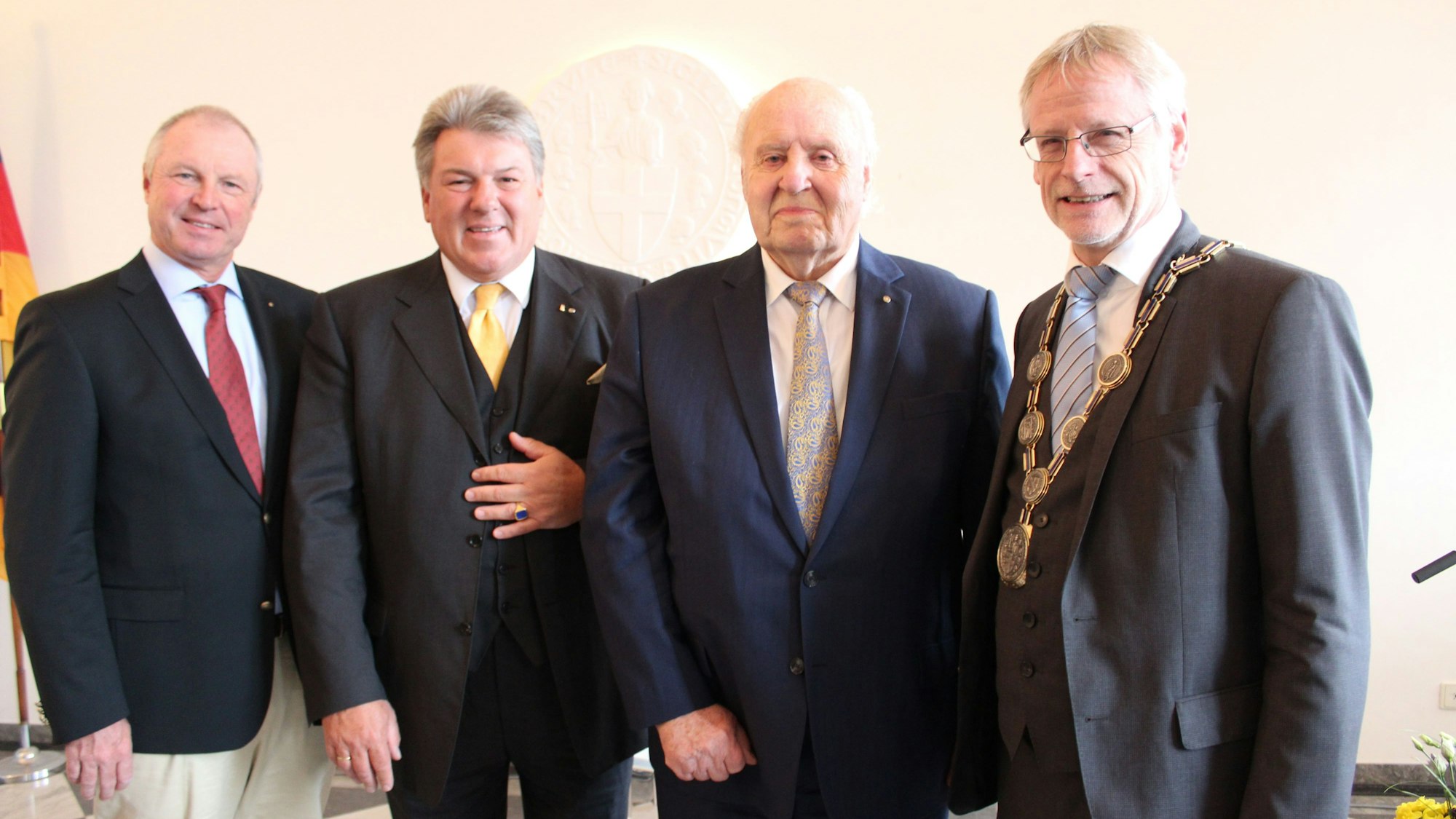 Auf dem Foto ist eine Gruppe von Männern in Anzügen zu sehen.