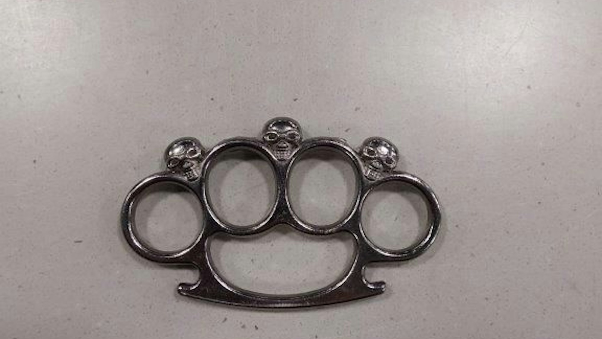 Ein metallischer Schlagring liegt auf einer Oberfläche.