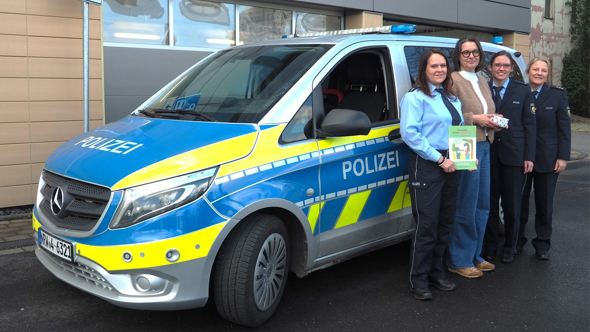 Die vier Frauen stehen an einem Streifenwagen.