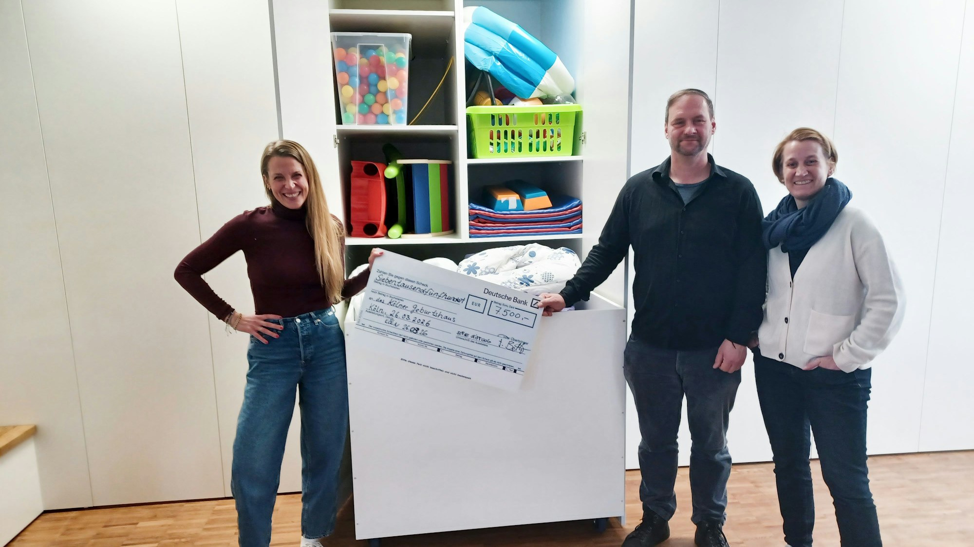 Drei Menschen präsentieren einen neuen Materialschrank.