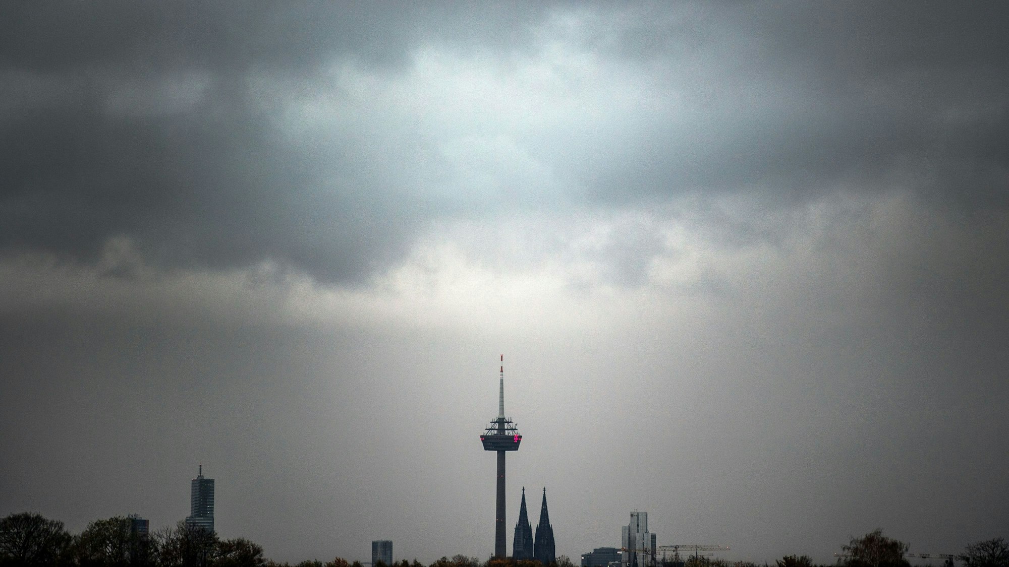Wolken ziehen am Morgen über den Kölner Dom und den Fernsehturm.