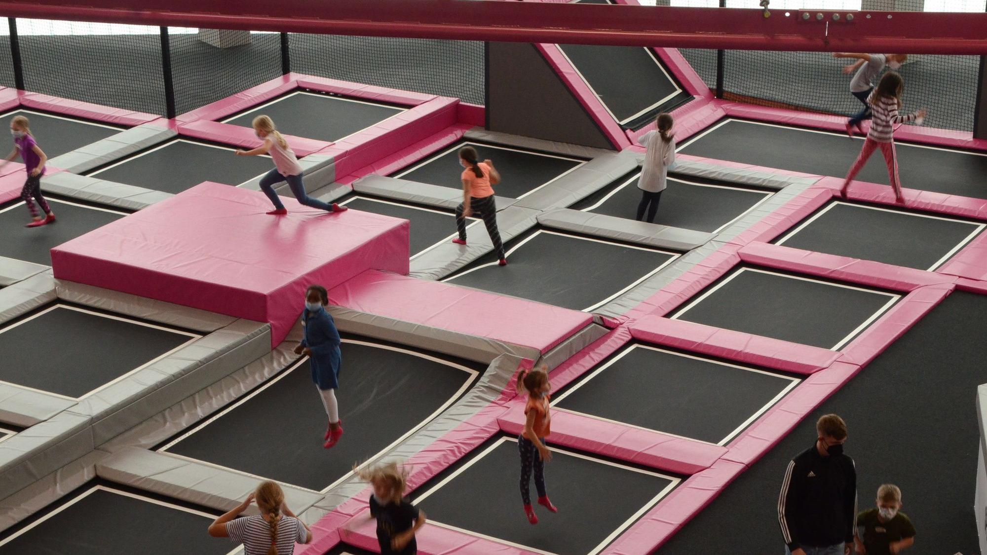 Kinder springen auf Trampolinen im Sprungraum.