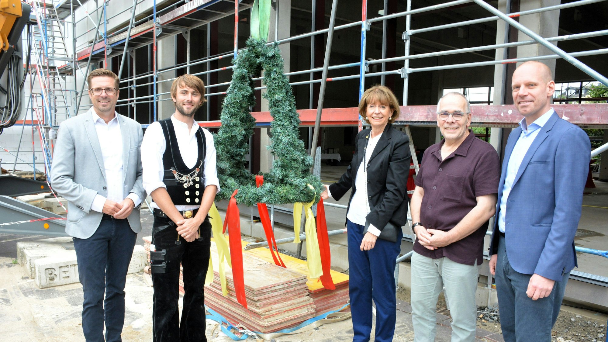 Wirtschaftsdezernent Andree Haack, Zimmermann Max Berheide, Oberbürgermeisterin Henriette Reker, Schulleiter Martin Süsterhenn und Tim Schneider von der Baufirma (v.l.) bei der Grundsteinlegung der Aula.