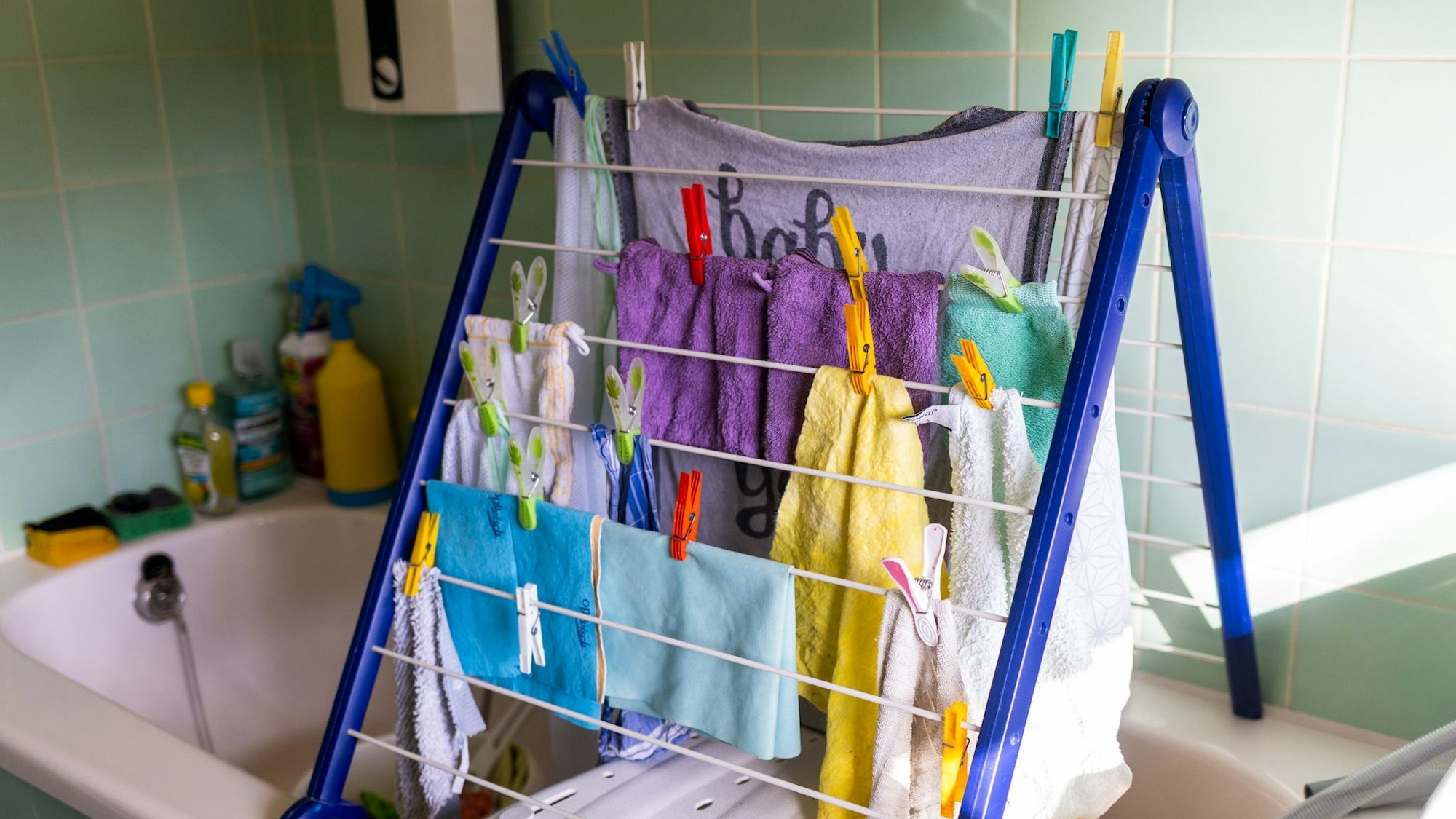 Putzlappen hängen über der Badewanne an einer Wäscheleine.