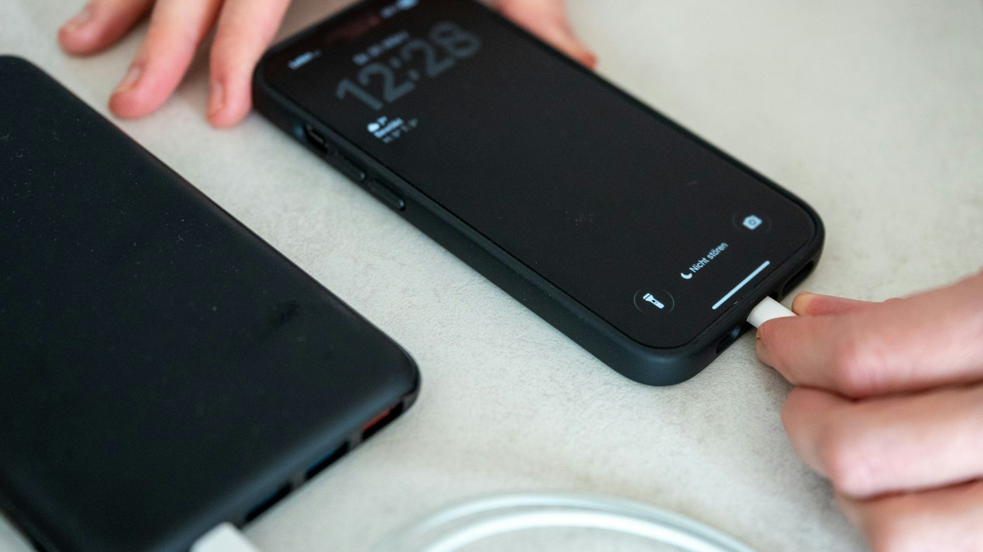 Eine Frau schließt ein iPhone an eine Powerbank an