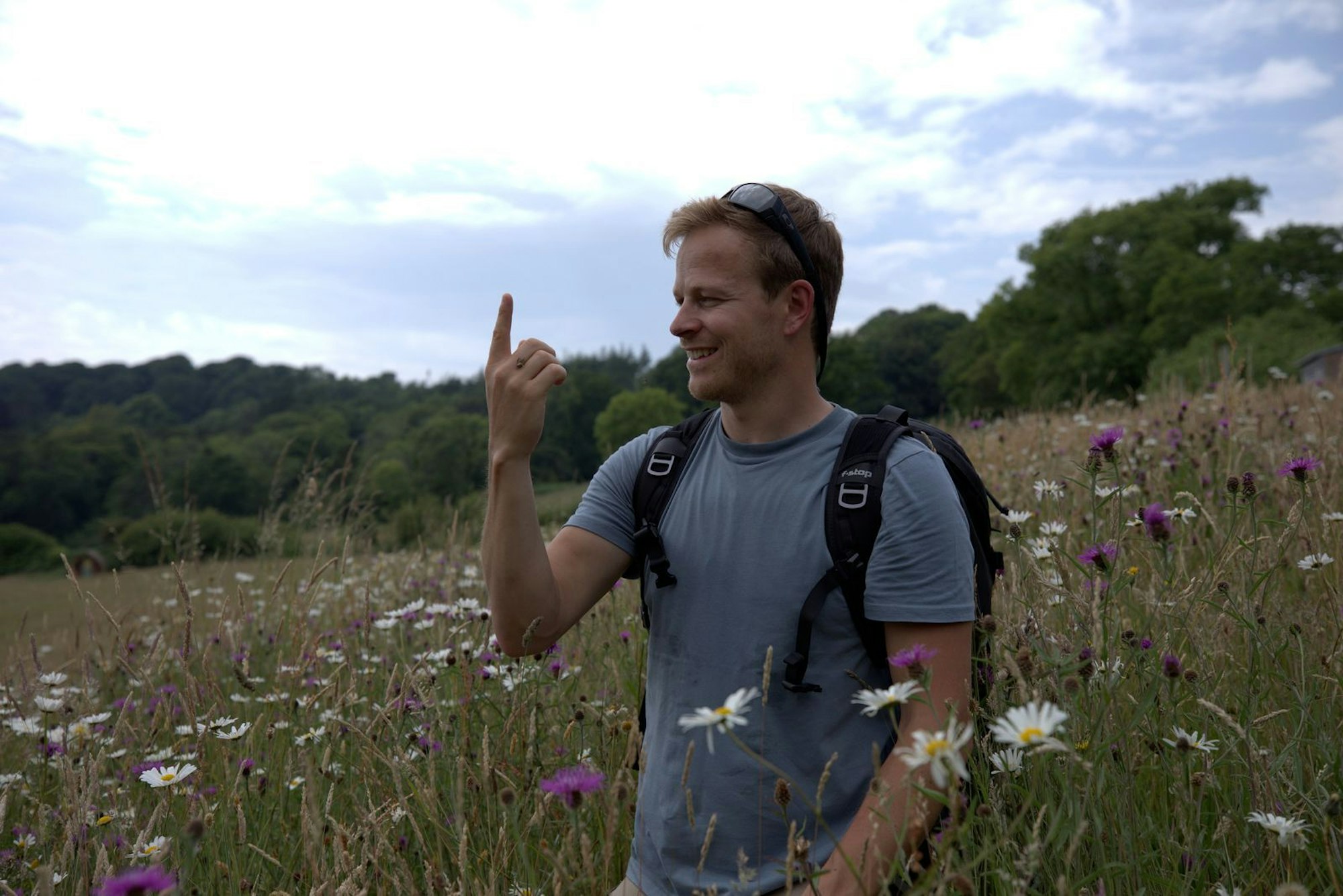 Bertie Gregory in einem Wildblumenfeld, mit einer seiner Protagonistinnen auf der Hand. (Bild: National Geographic)