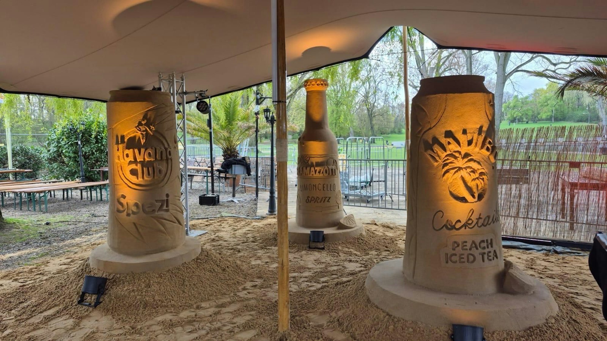 Josef Rayes, der Betreiber des Biergartens und Yosef Bakir Sandkünstler vor der Flasche des Aachener Weihers