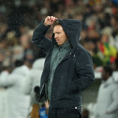 Julian Nagelsmann richtet sich im Regen die Kapuze.