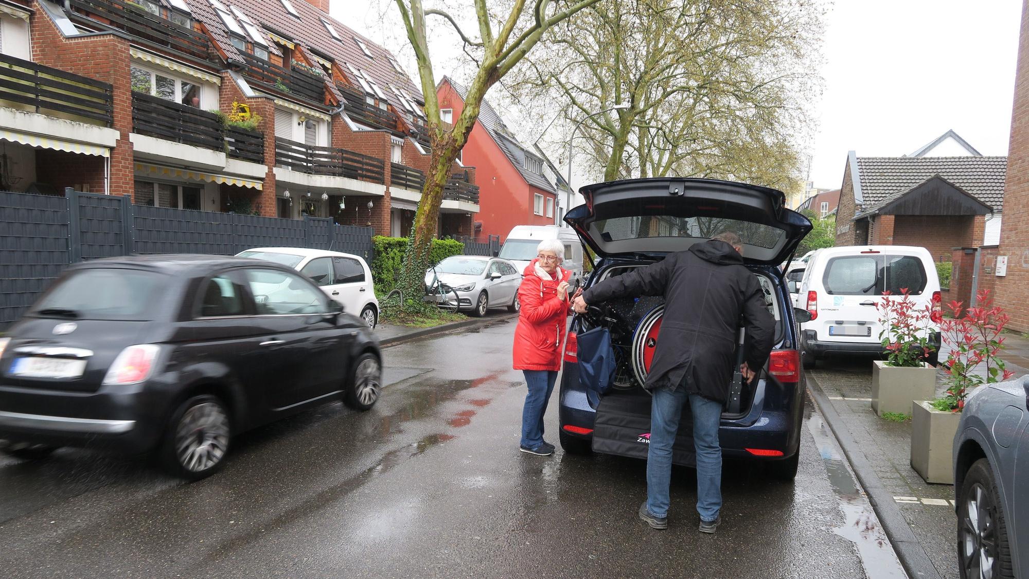 Nicht ungefährlich: Claudia Baltzheim und Hans Peter Bochem müssen den Rollstuhl vor Gut Pisdorhof in zweiter Reihe ein- und ausladen.