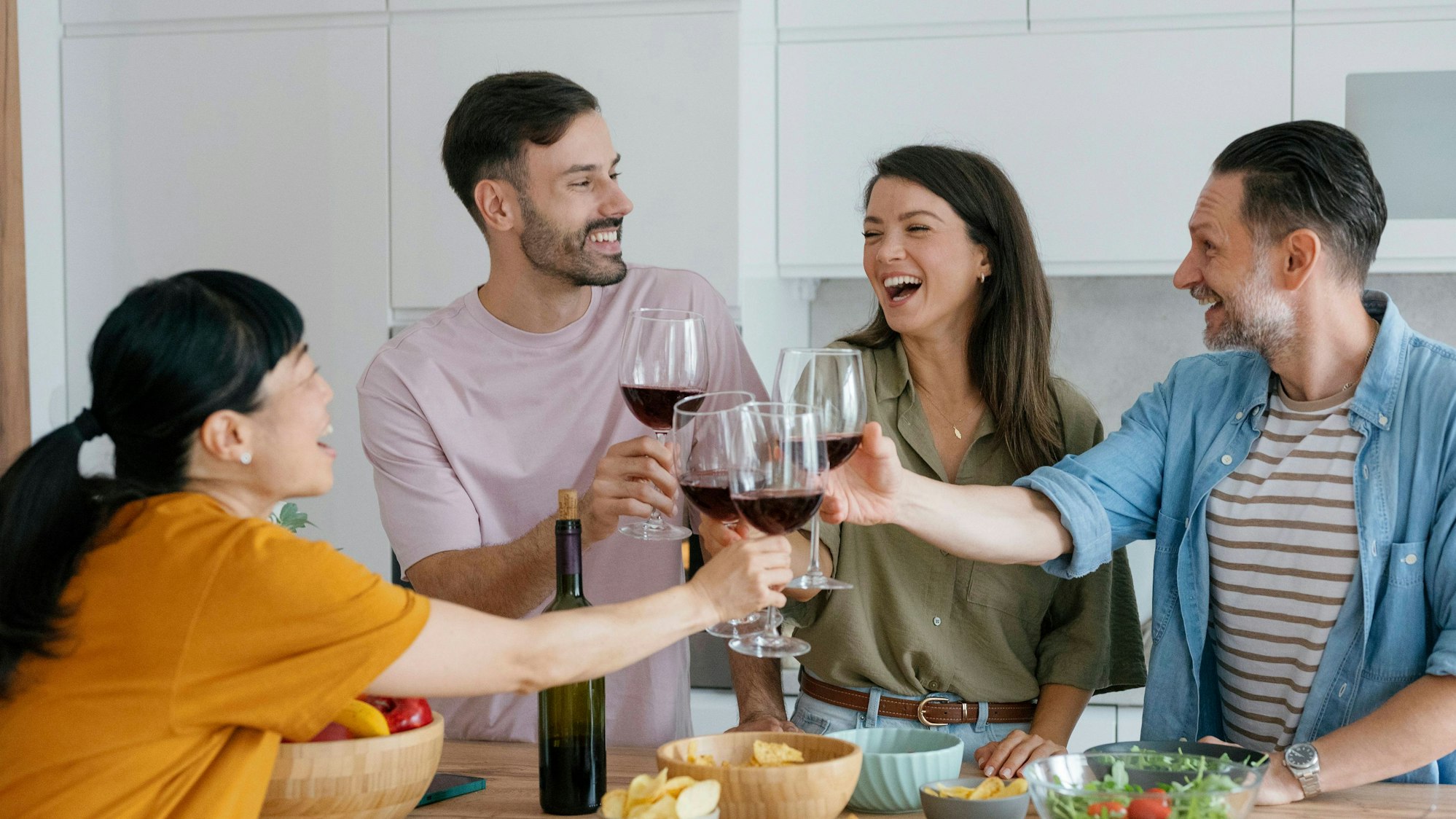 Freunde stoßen gemeinsam mit Wein an.