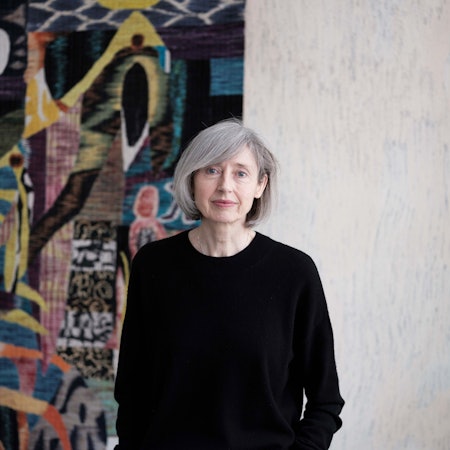 Gisela Capitain steht vor einer Wand.