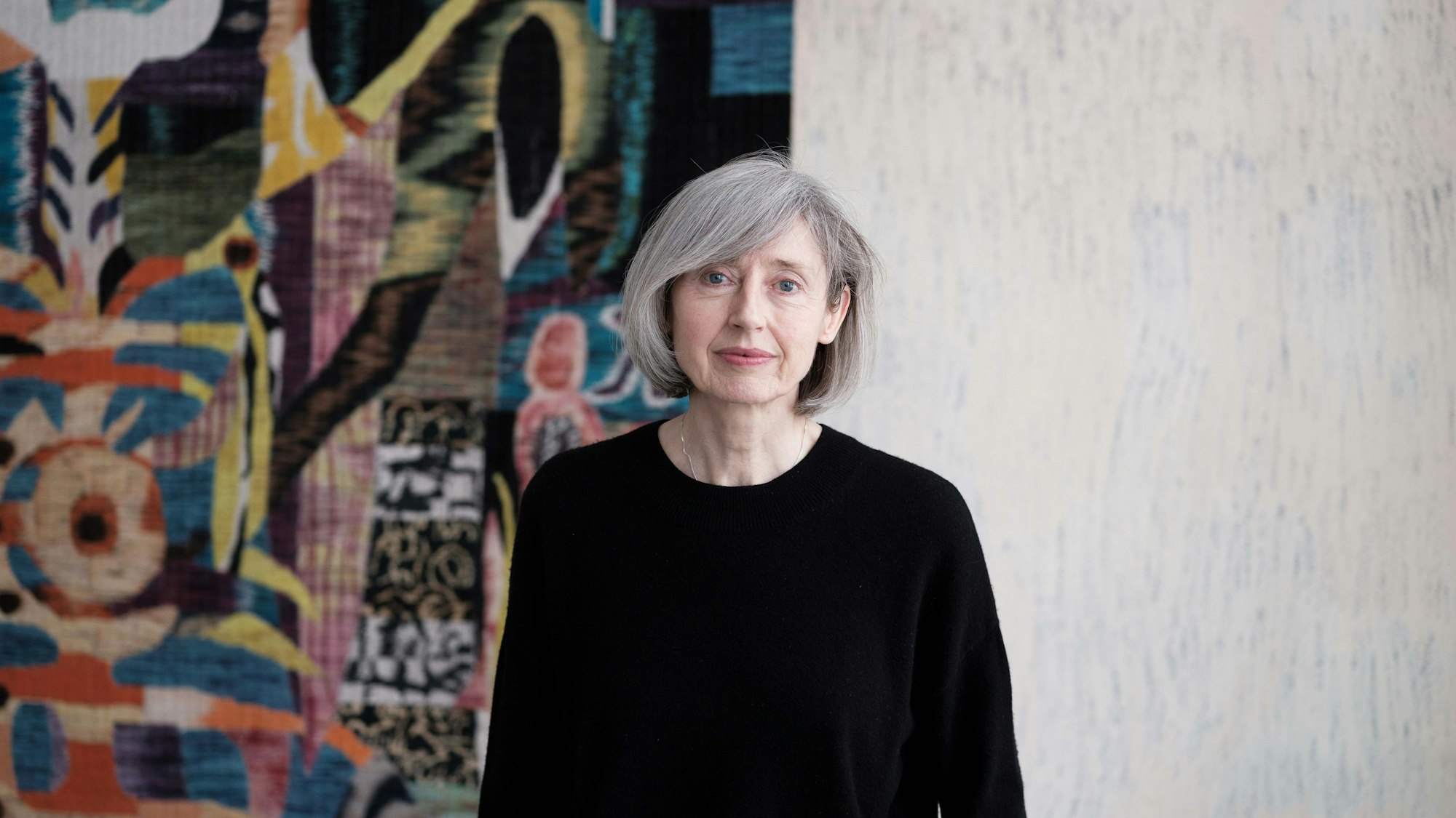 Gisela Capitain steht vor einer Wand.