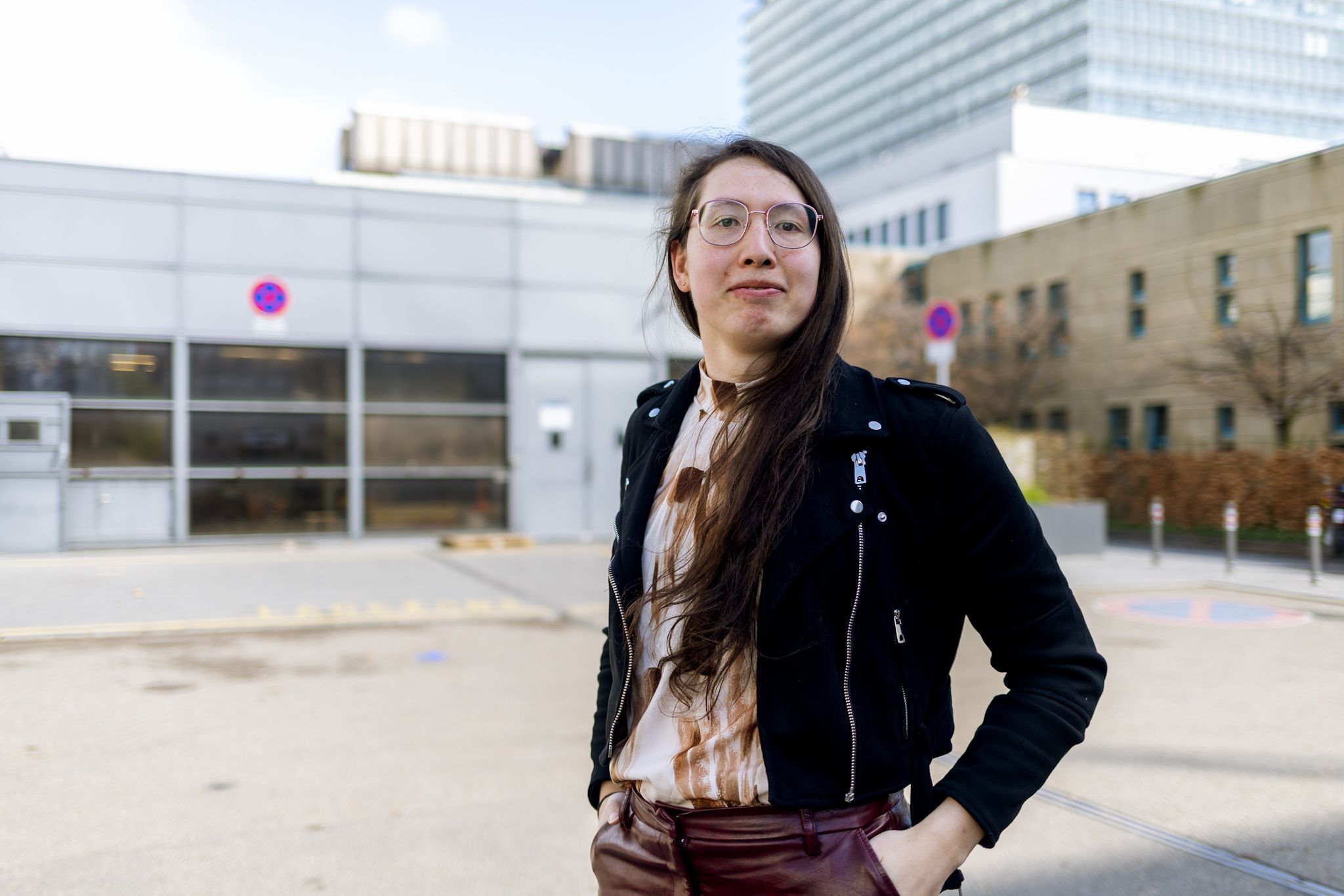 Eine junge Frau in Lederjacke lächelt in die Kamera.