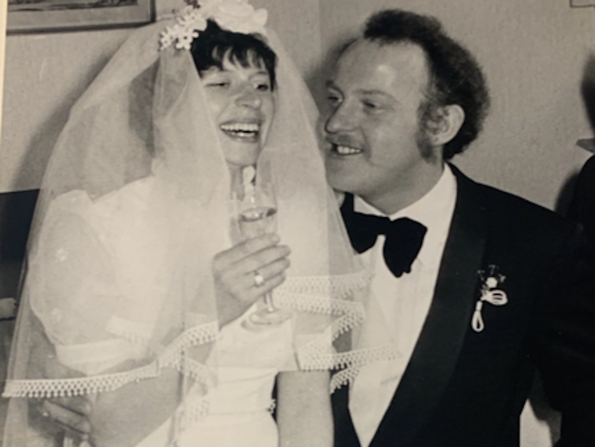 Ein Brautpaar mit Sektgläsern in der Hand.