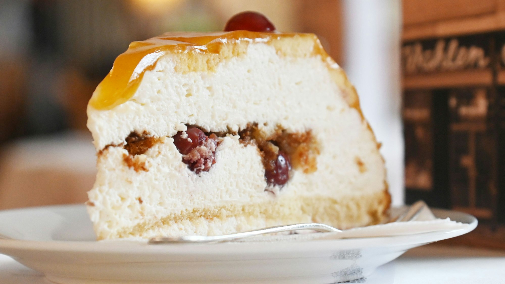 Ein Stück Kuchen mit Kirschfüllung liegt auf einem Kuchenteller.