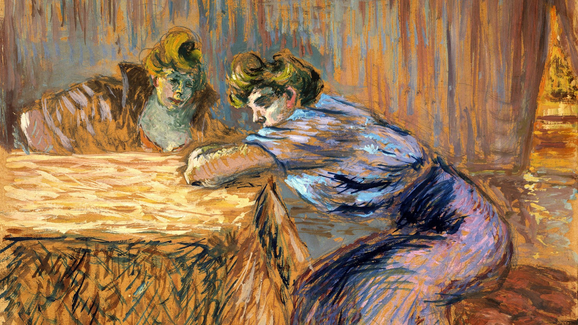 Zwei Frauen sitzen an einem Tisch.