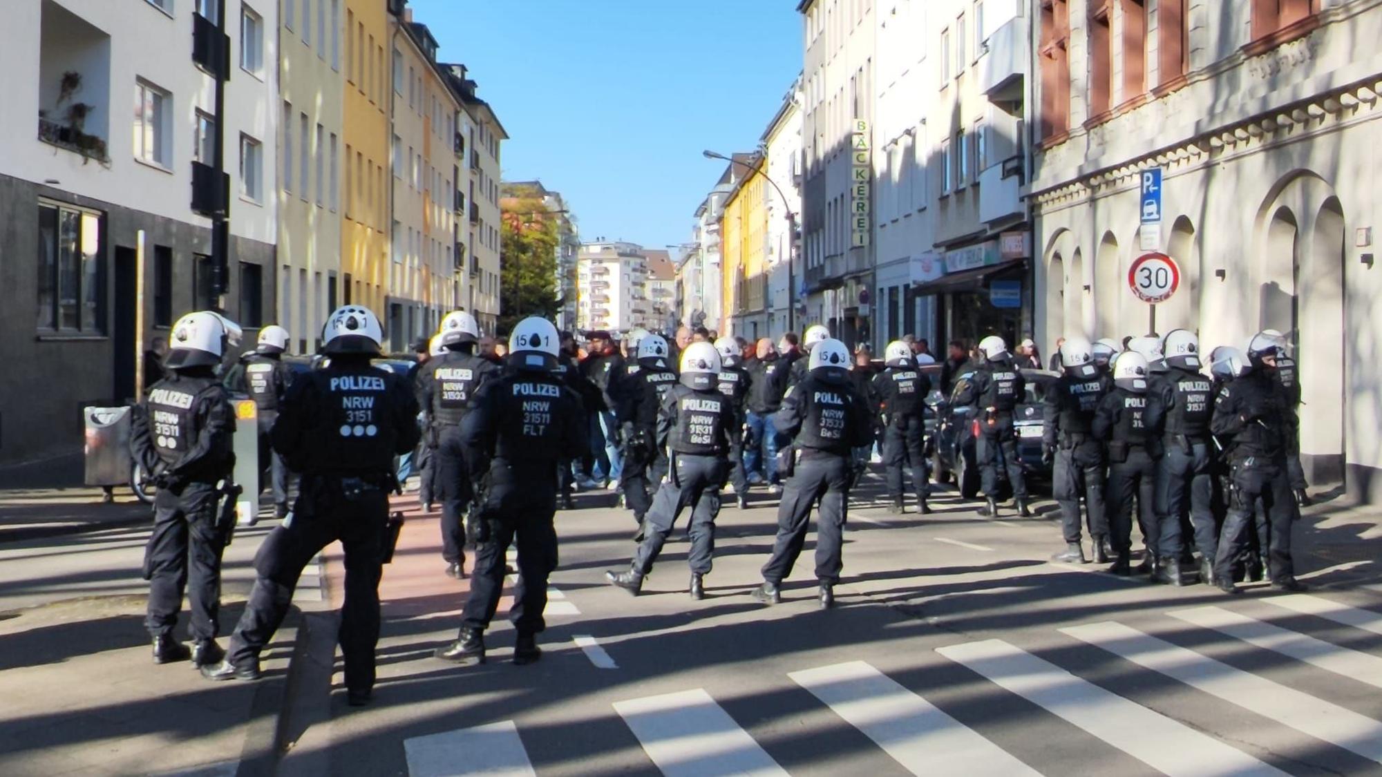 Bei einem Polizeieinsatz in der Kölner Südstadt versperrt am 1. April 2026 eine Einsatzhundertschaft den Weg.