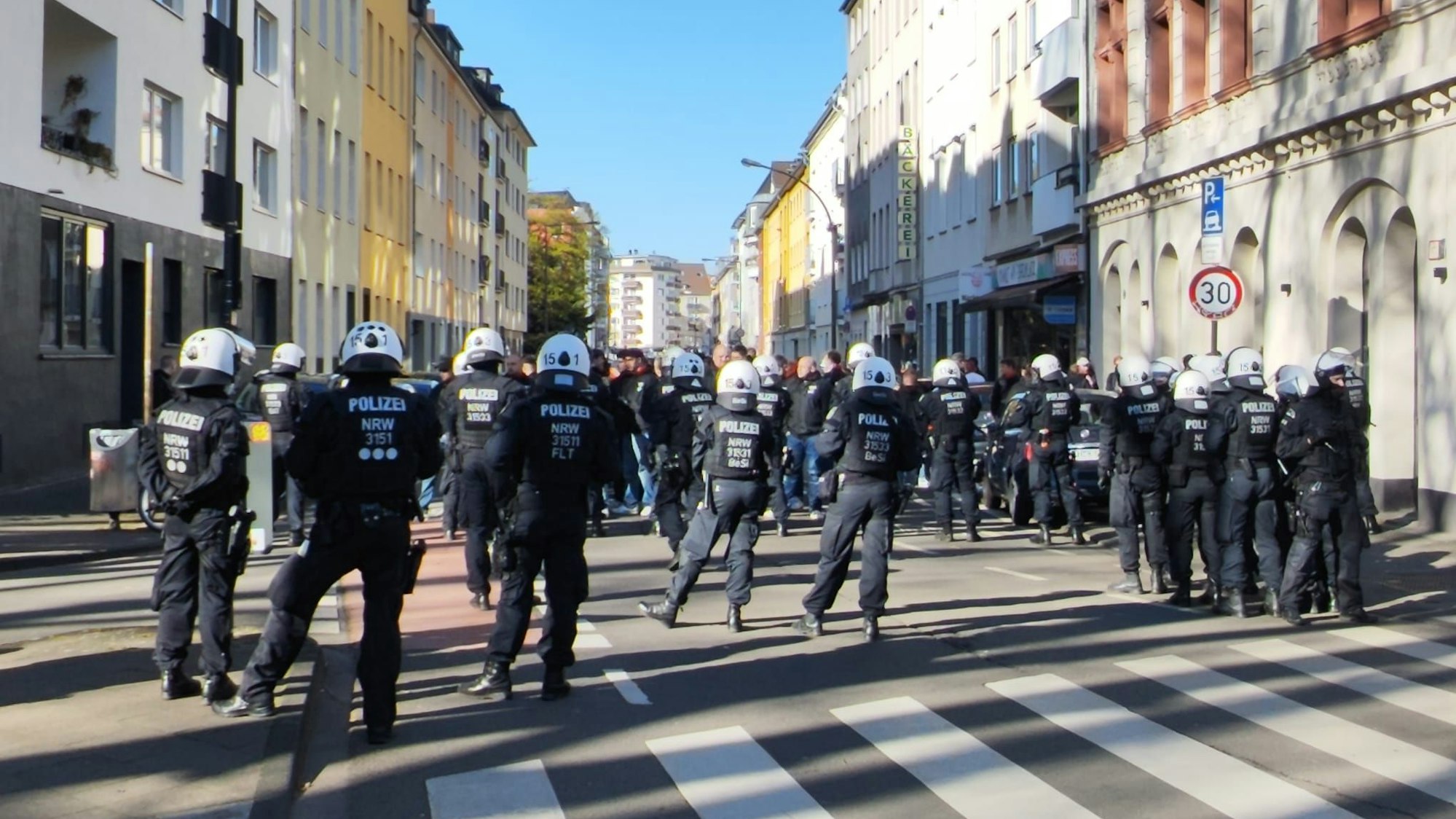 Bei einem Polizeieinsatz in der Kölner Südstadt versperrt am 1. April 2026 eine Einsatzhundertschaft den Weg.