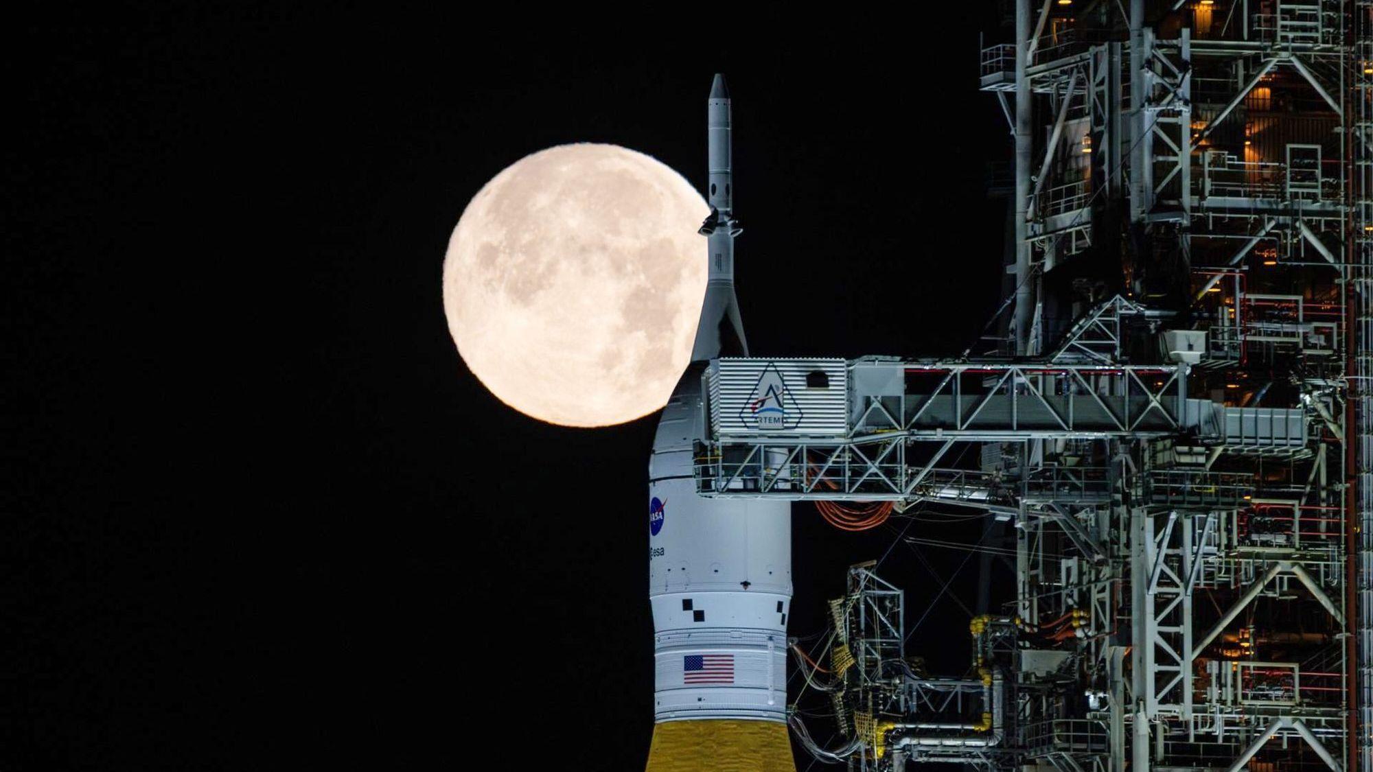 Der Vollmond scheint in den frühen Morgenstunden im Kennedy Space Center der Nasa in Florida über dem SLS ("Space Launch System") und dem Orion-Raumschiff der NASA, die sich auf der mobilen Trägerrakete „Artemis 2“ befinden.