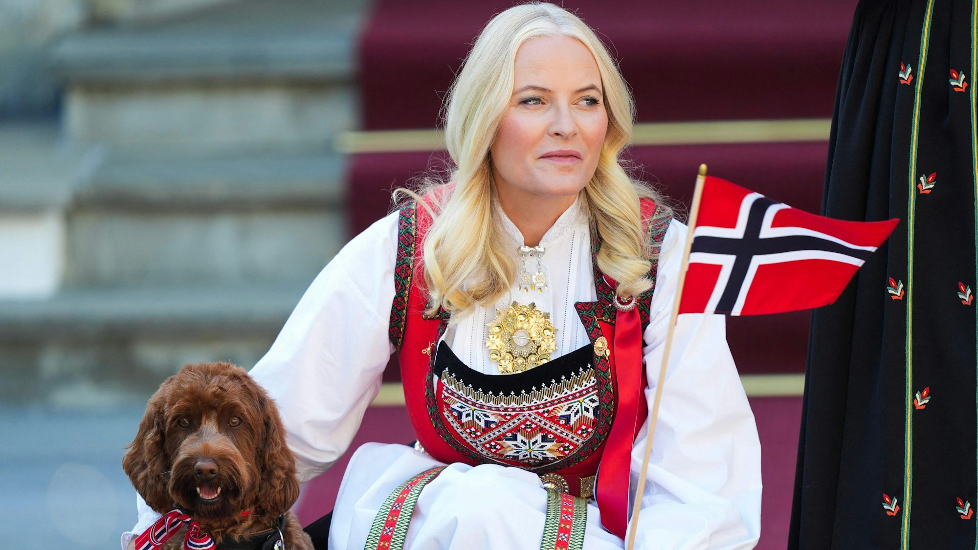 Kronprinzessin Mette-Marit mit norwegischer Fahne und Hund.