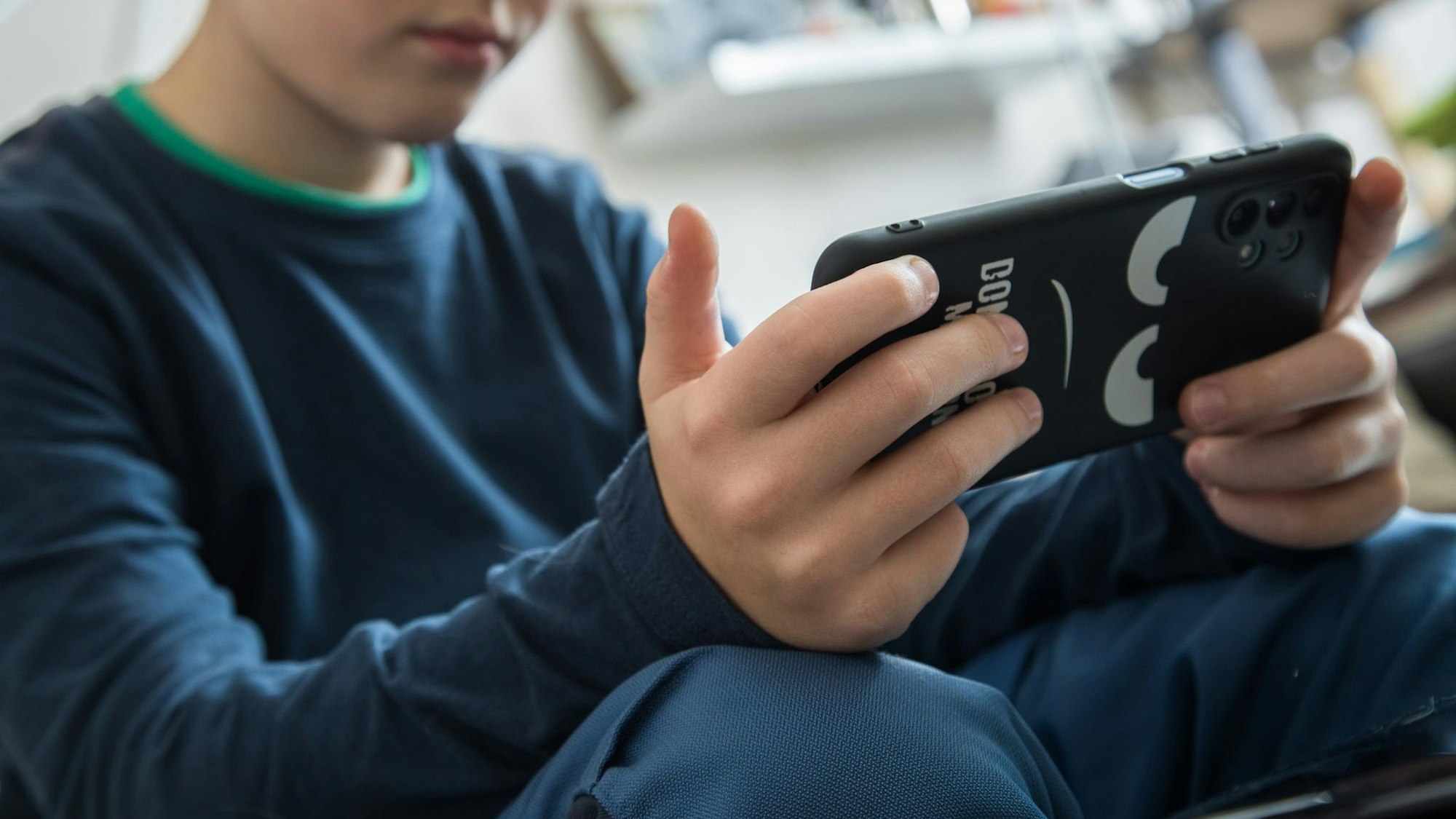 Junge schaut auf sein Smartphone