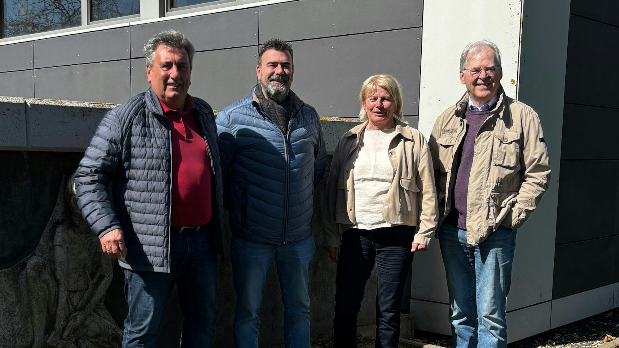 Das Foto zeigt vier Personen, die nebeneinander stehen.