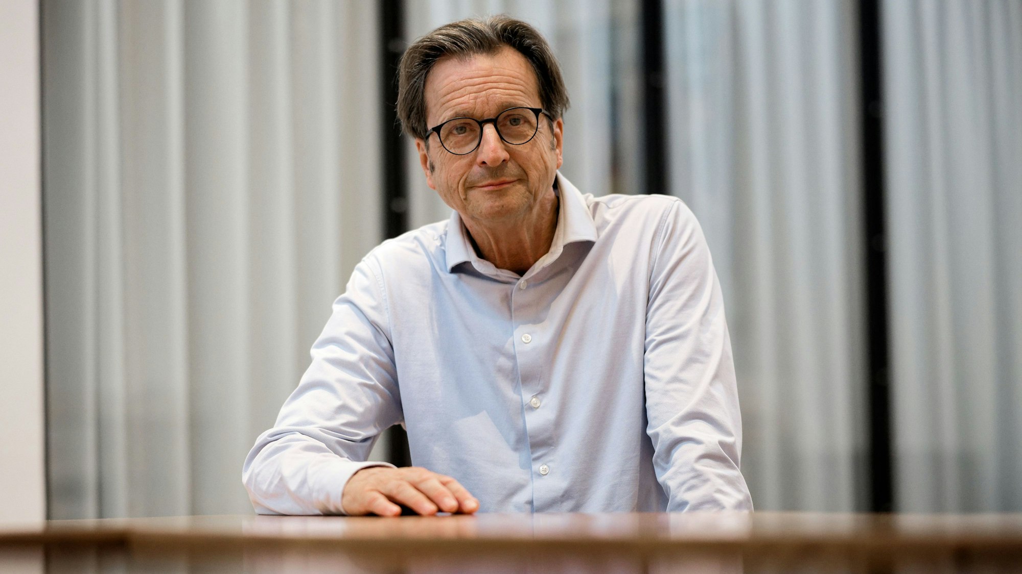 Rheingold-Gründer Stephan Grünewald sitzt bei einem Interview über sein neues Buch "Wir Krisenakrobaten - Psychogramm einer verunsicherten Gesellschaft" in einem Besprechungsraum.