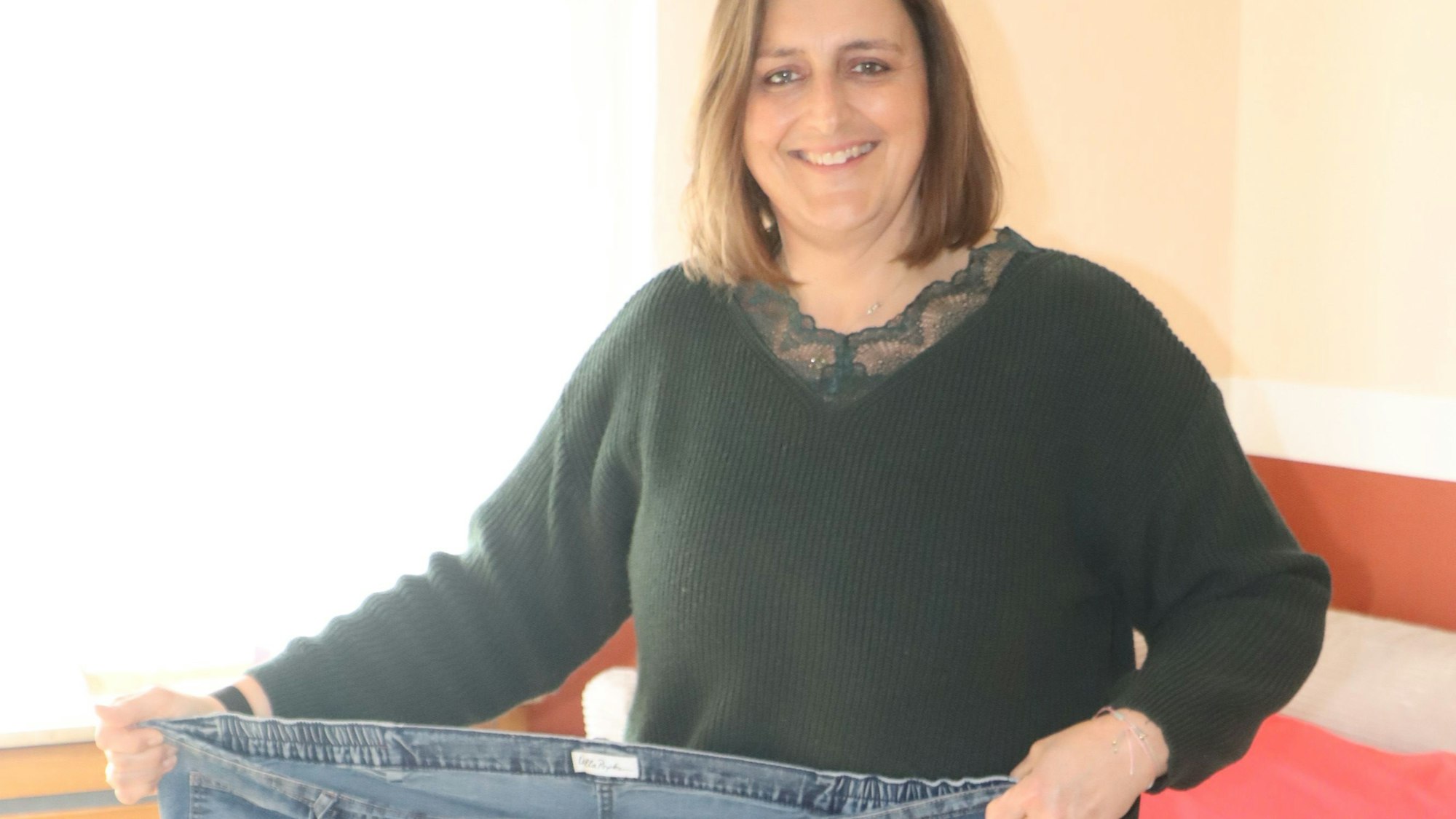 Eine Frau hält eine Hose.