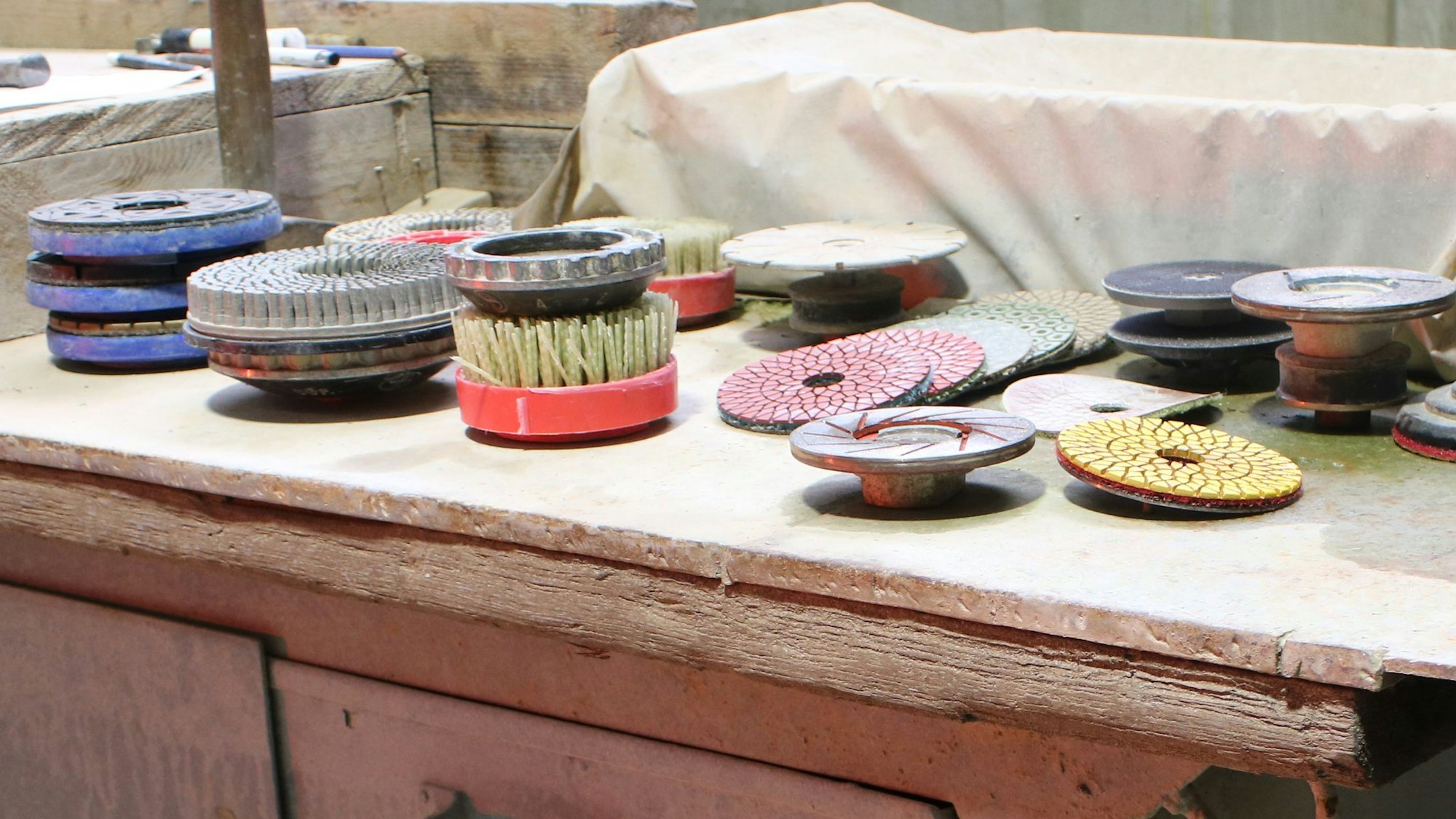 Schleifköpfe und Bürsten liegen auf einem Tisch.