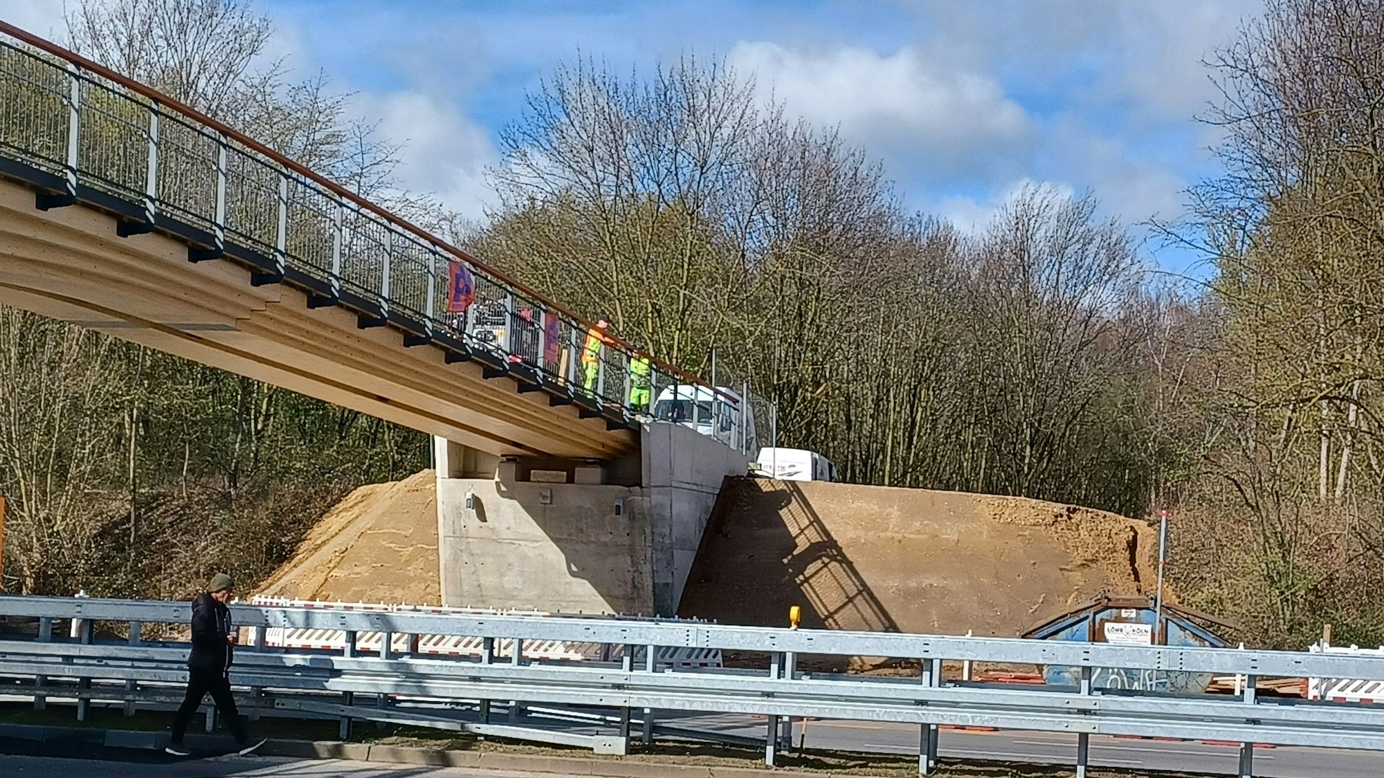 Die Holzbrücke über die Äußere Kanalstraße ist nahezu fertig. Anne Grose und Roland Schüler (r.) kritisieren jedoch die Rodungen seitlich der Brückenköpfe.