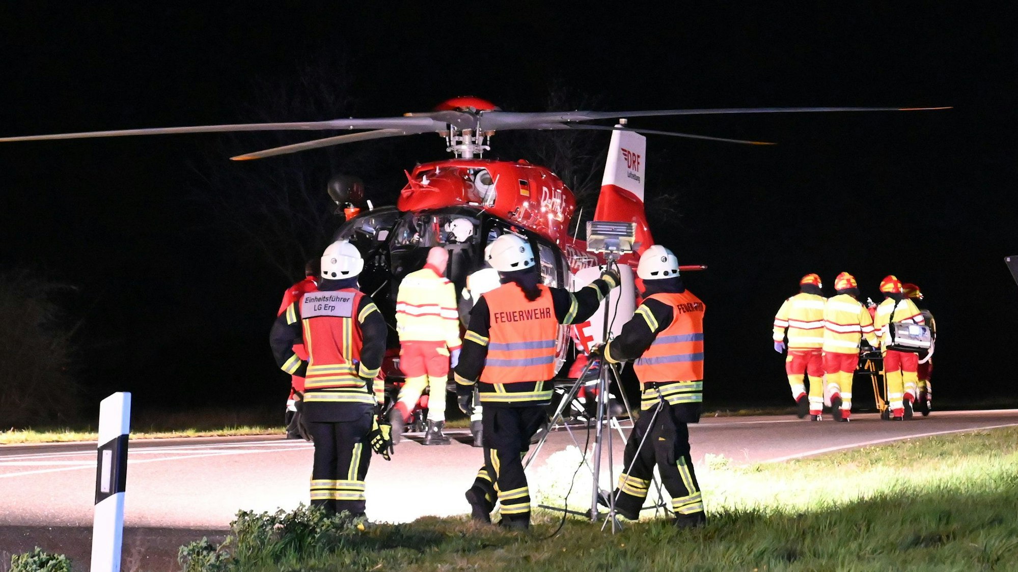 Das Bild zeigt einen Rettungshubschrauber und mehrere Einsatzkräfte von Feuerwehr und Rettungsdienst.