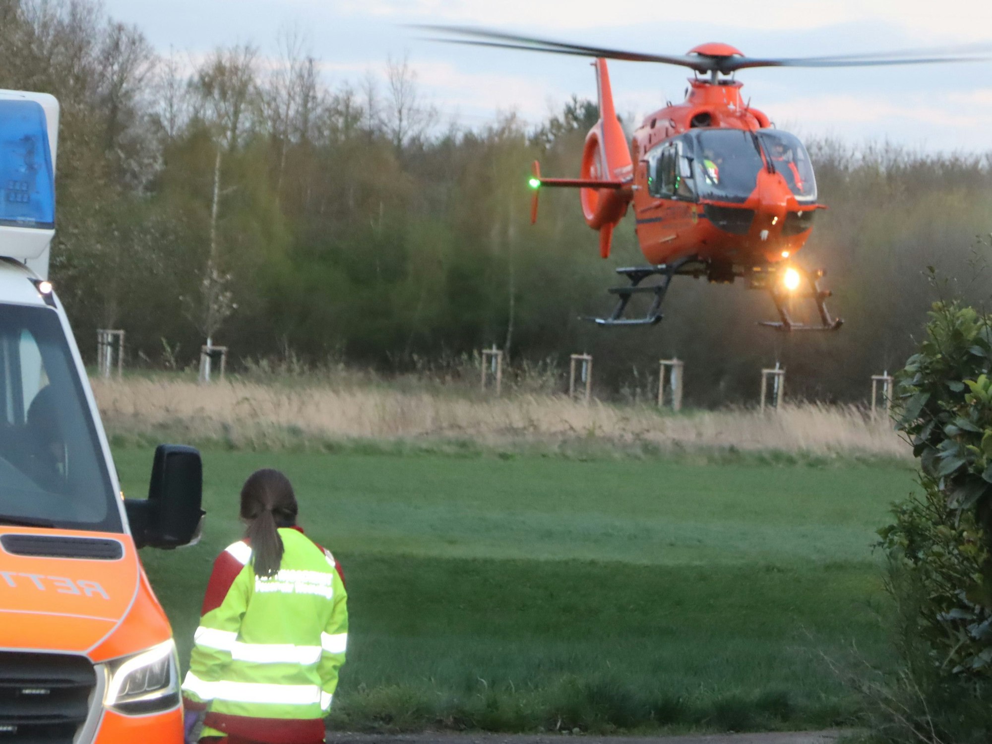 Das Bild zeigt einen Rettungshubschrauber neben einem Rettungswagen.