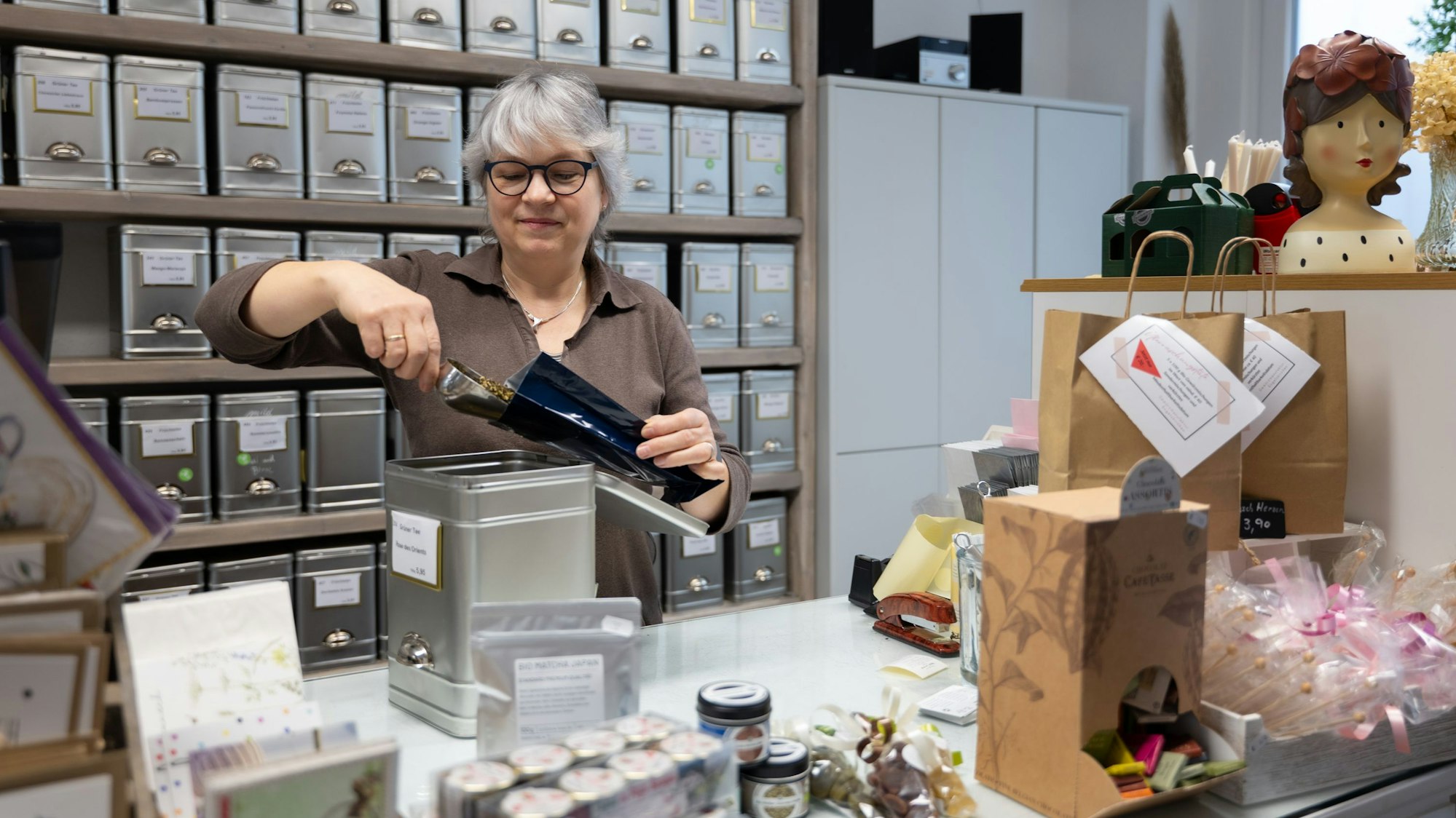 Eine Frau füllt in einem Teeladen Tee ab.