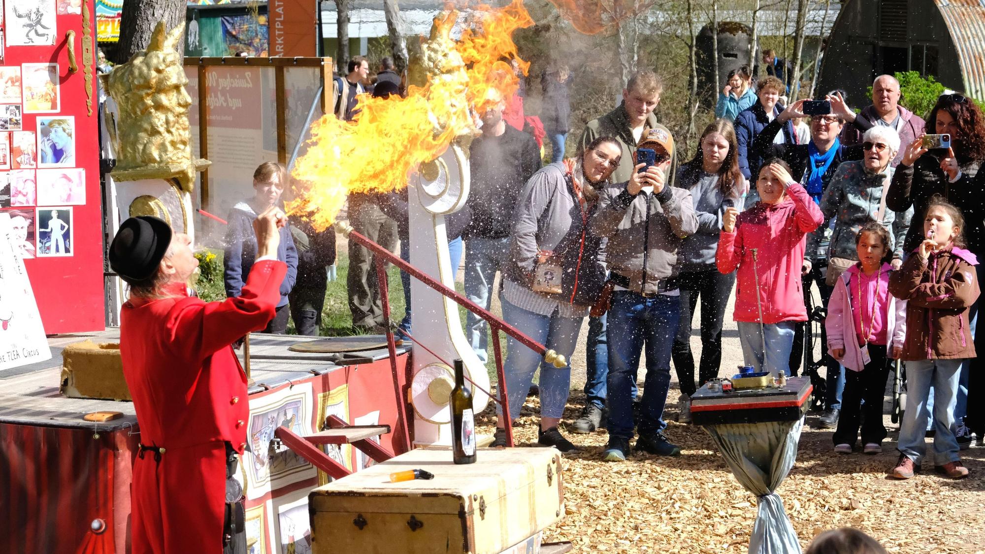 Gilbert, der Gaukler, beim Feuerspucken vor seinem Publikum im Freilichtmuseum.