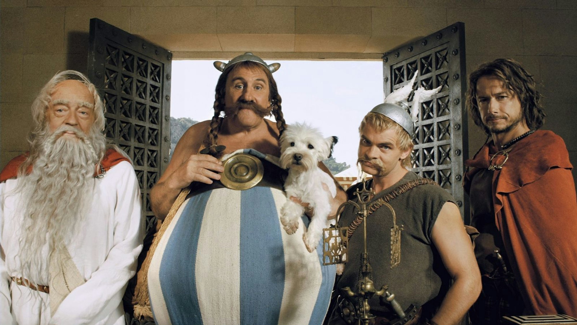 Asterix (Clovis Cornillac, zweiter von rechts) und Obelix (Gérard Depardieu, zweiter von links) sind mit Miraculix (Jean-Pierre Cassel, links) in Griechenland, um ihrem Freund Romantix (Stéphane Rousseau) zu helfen. (Bild: Constantin Film)