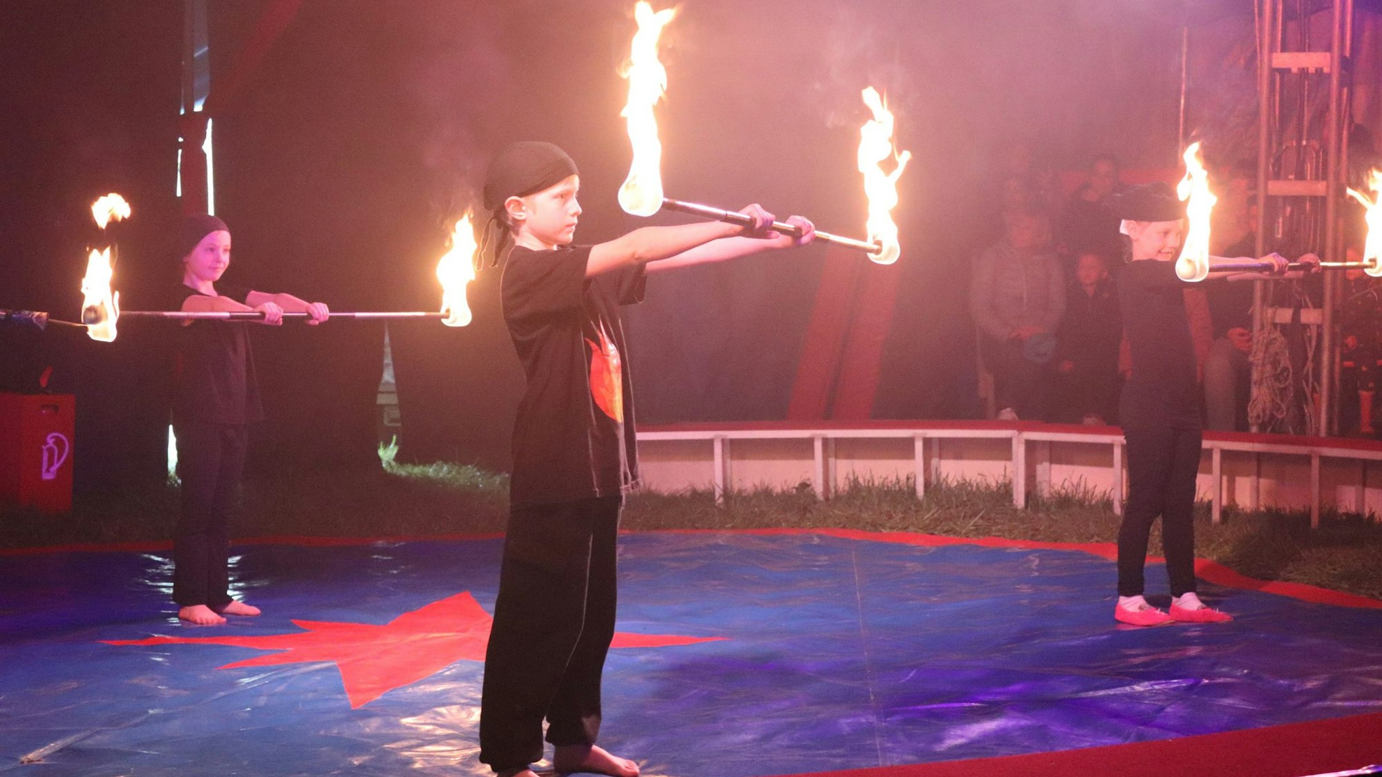 Kinder mit Fackeln in der Manege
