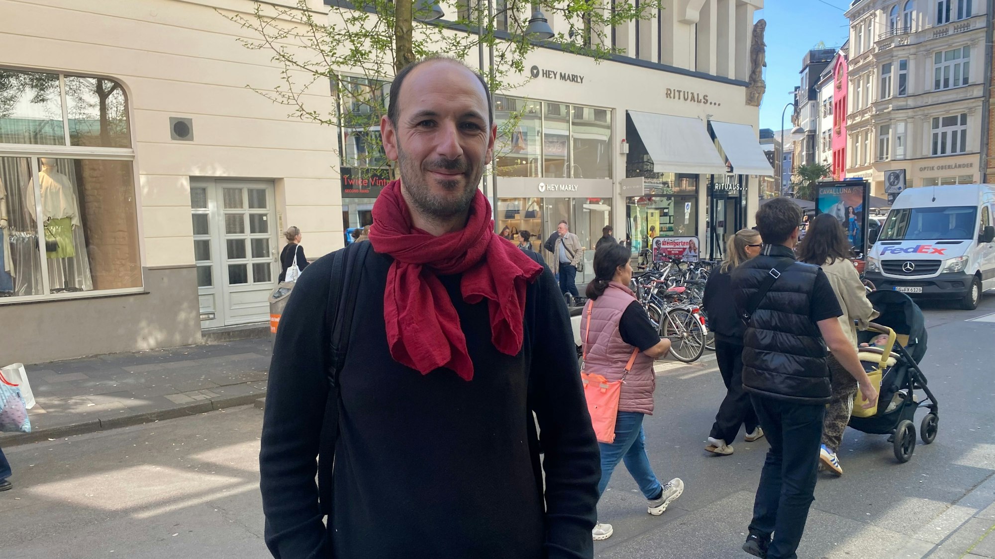 Ein Mann mit rotem Schal schaut in die Kamera.