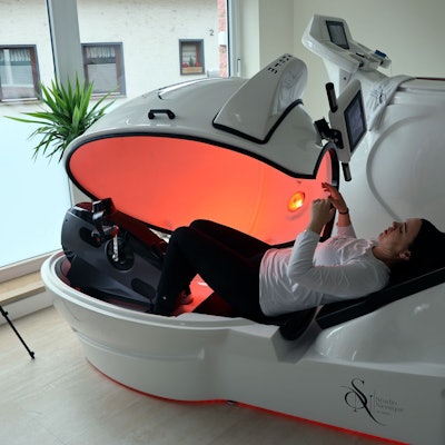 Eine Frau liegt in einem Liegerad mit Infrarotstrahlen.