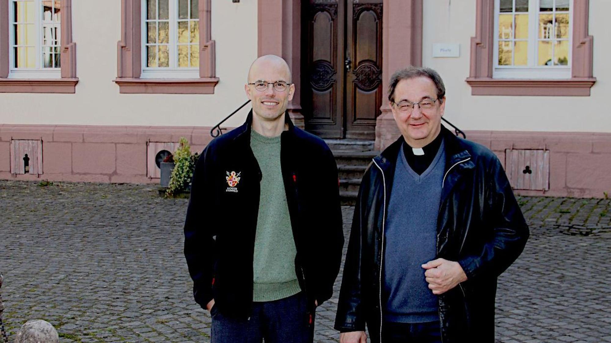 Zwei Männer stehen vor einem der Klostergebäude.