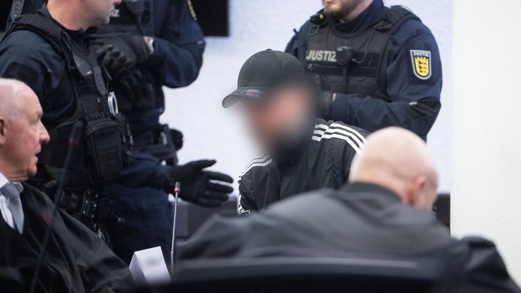 Stuttgart: Ein Angeklagter (M.), der als Unfallverursacher wegen Mordes zu lebenslanger Haft verurteilt worden ist, sitzt am 7. April vor der Urteilsverkündung im Prozess wegen Mordes an zwei jungen Frauen in einem Saal des Landgerichts.
