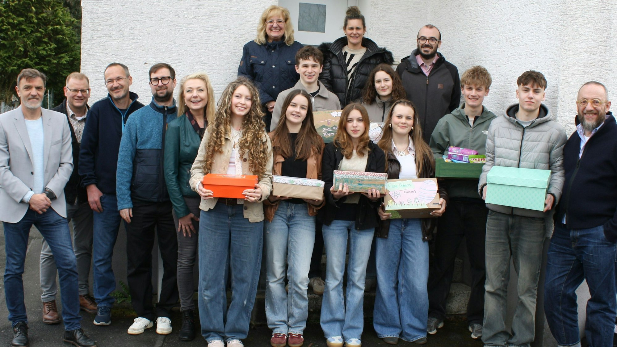 Zu sehen sind Schülerinnen, Schüler und Verantwortliche mit Geschenkboxen.