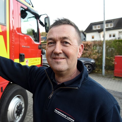 Enrico Werner öffnet die Tür eines Feuerwehrautos.