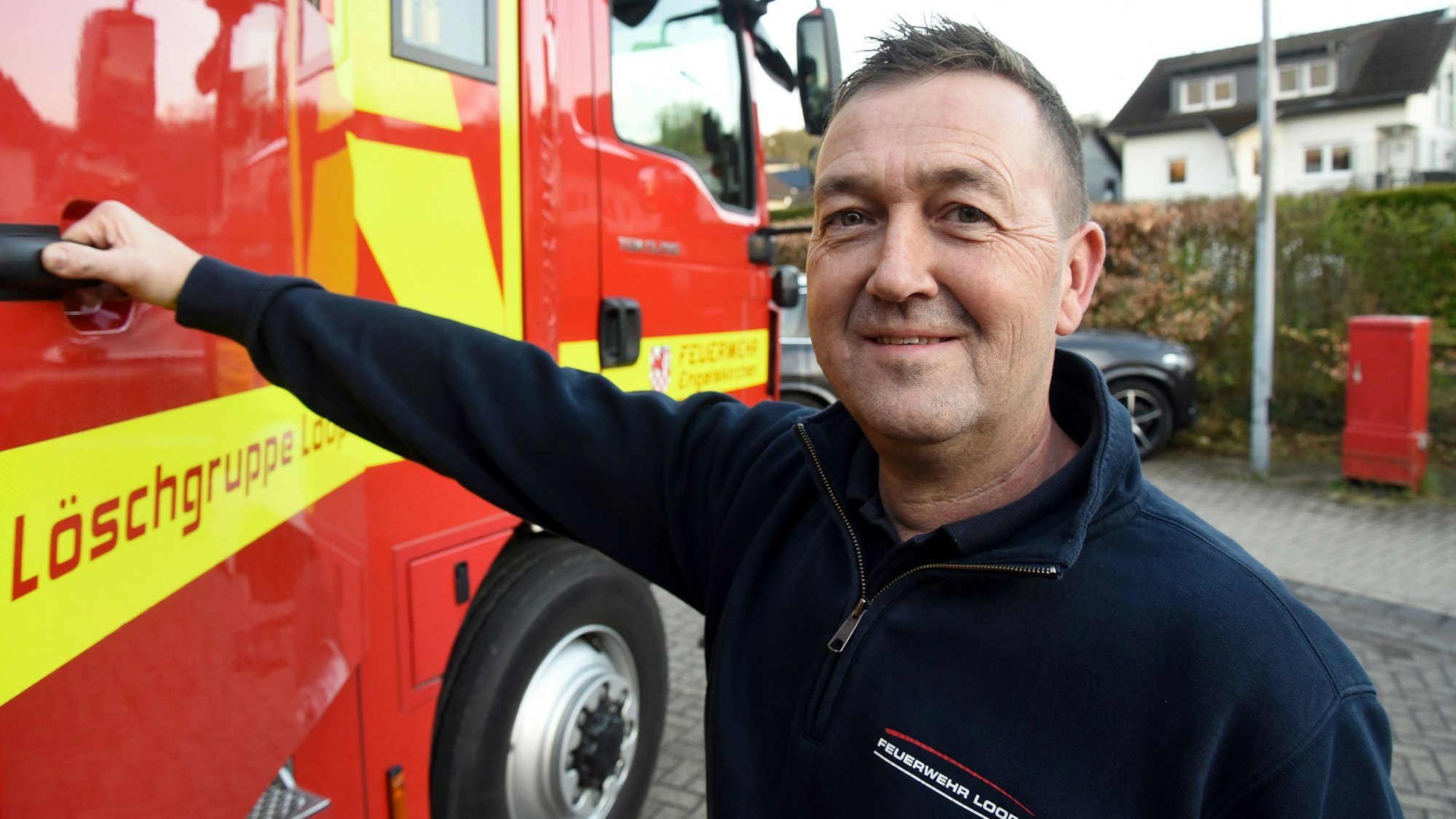 Enrico Werner öffnet die Tür eines Feuerwehrautos.