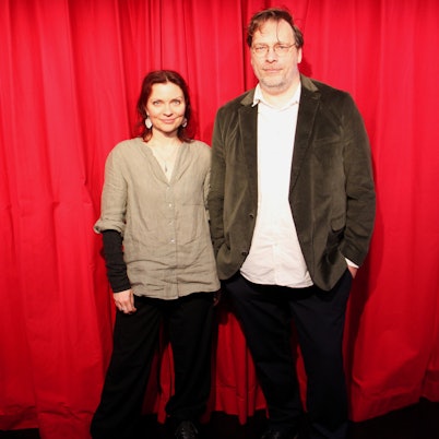 Eine Frau und ein Mann stehen vor einem roten Vorhang.