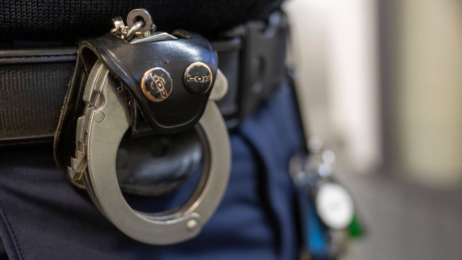 Eine Handschelle hängt am Gürtel eines Polizisten. Die Schlüssel dafür sind im Internet erhältlich.