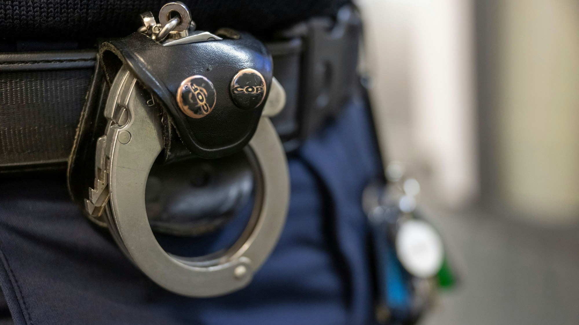 Eine Handschelle hängt am Gürtel eines Polizisten. Die Schlüssel dafür sind im Internet erhältlich.