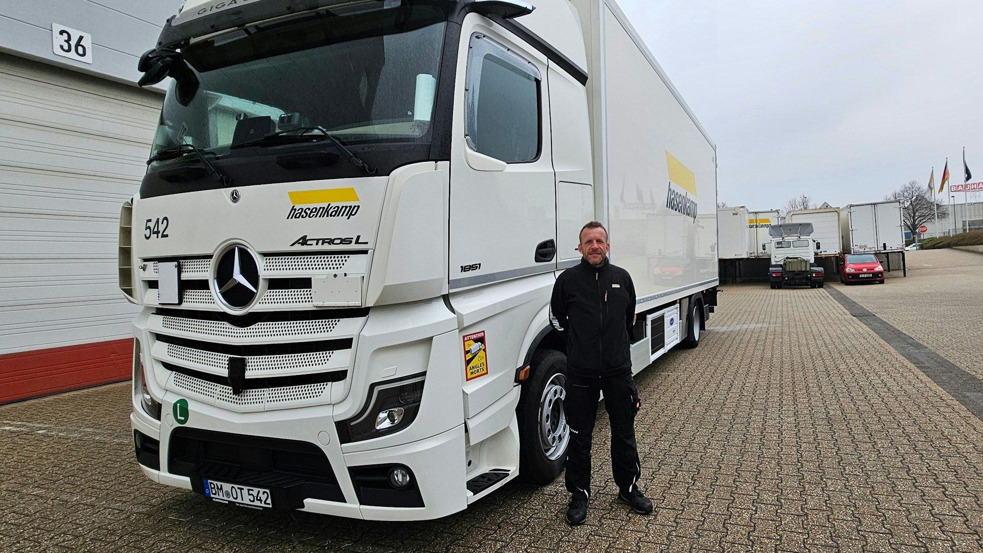 Zu sehen ist ein Mann vor einem Lkw.