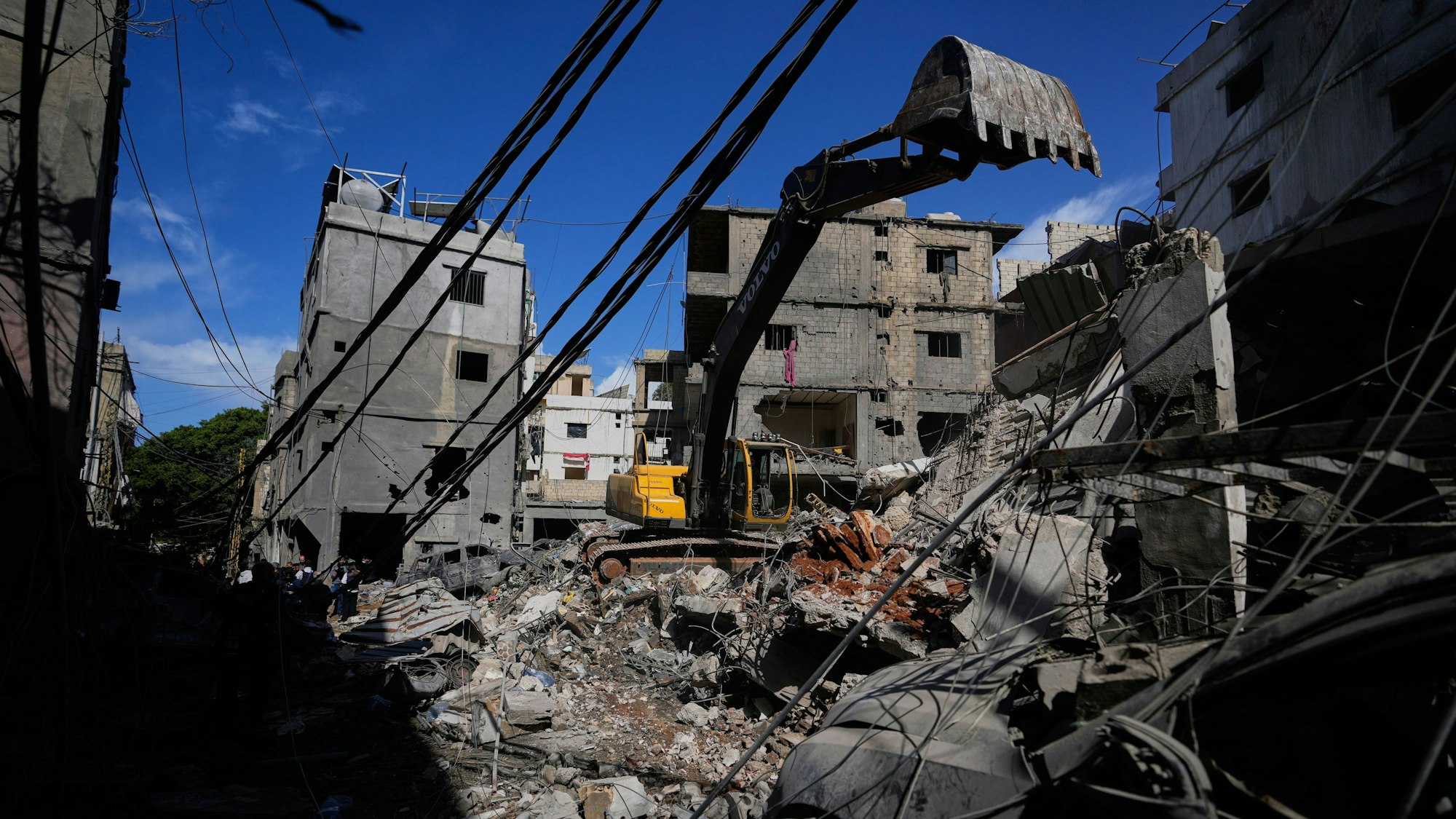Ein Bagger räumt Trümmer an der Stelle eines beschädigten Gebäudes, nachdem dort ein Auto aus dem Schutt geborgen wurde. Die Arbeiten folgen auf einen israelischen Angriff vom Sonntag auf ein Gebäude im Beiruter Stadtteil Jnah.