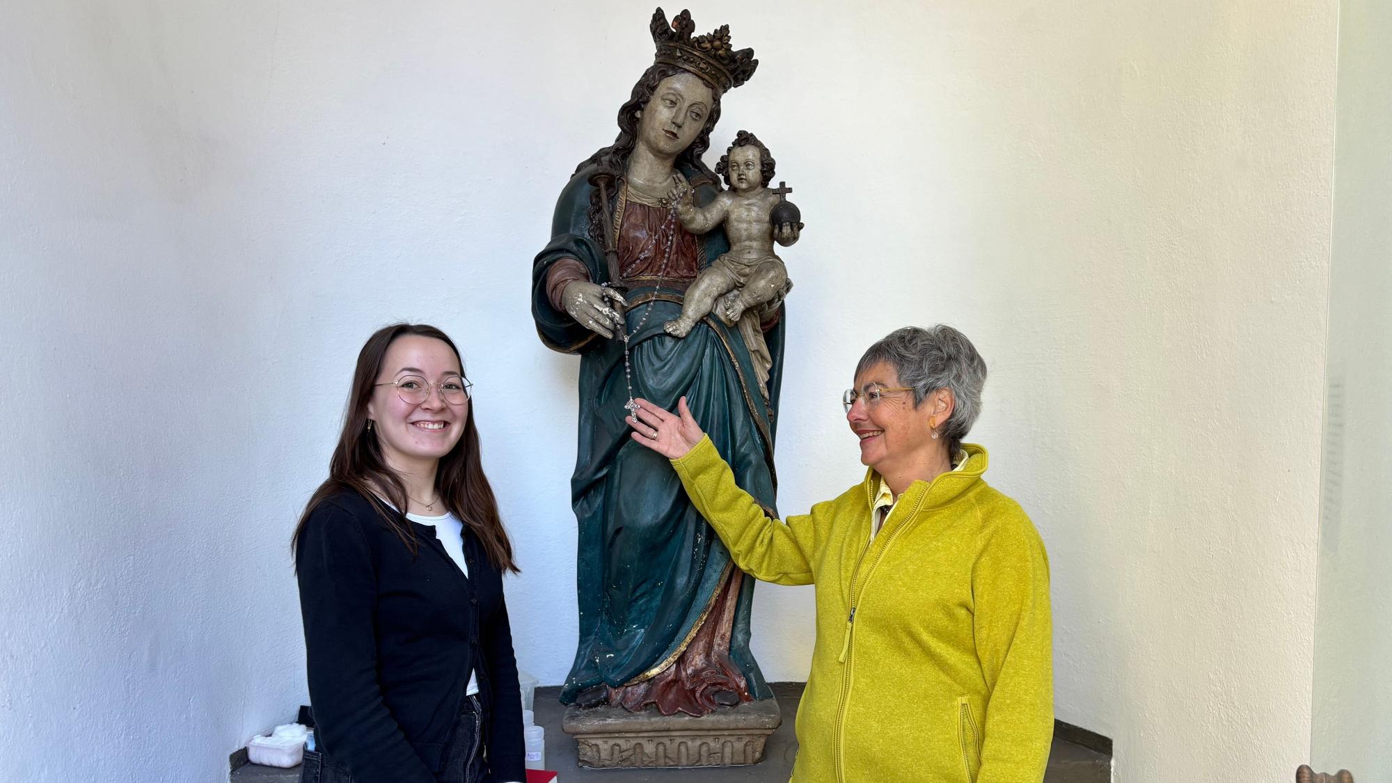 Die Obengenannten flankieren eine barocke Marien-Figur mit Jesus-Kind. und lächeln Dr. Andrea Korte-Böger gestikuliert mit einer Hand und schaut in Richtung von Johanna Baldus.