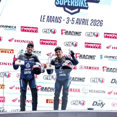 Zu sehen ist die Siegerehrung von zwei Rennfahrern.